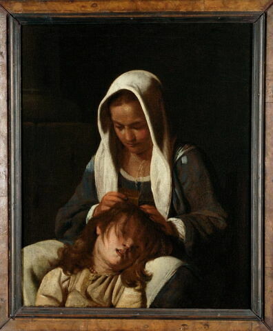 Femme épouillant un enfant