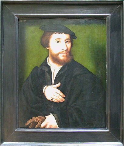 Portrait d'homme habillé de noir et tenant d'une main ses gants, image 3/3