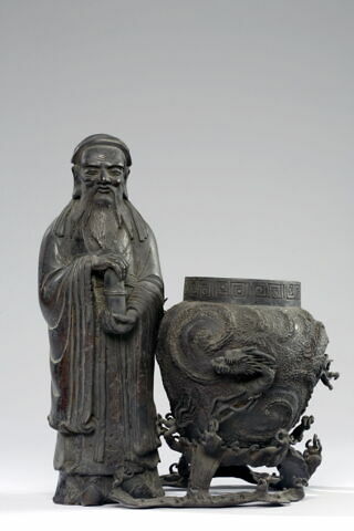 Personnage chinois debout à côté d'un vase