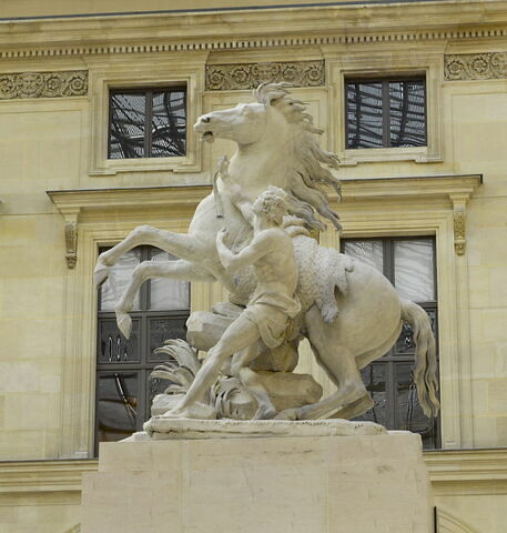 Cheval retenu par un palefrenier