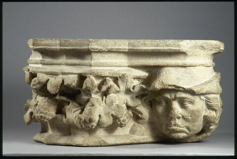 Chapiteau décoré d'une tête d'homme coiffé d'un bonnet, de feuilles de vigne et de grappes de raisin, image 2/3