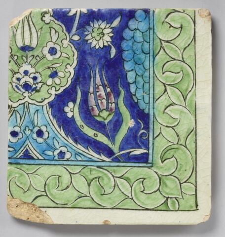 Carreau d'angle à réseau fleuri enfermant un végétal écailleux et une tulipe sur fond bleu sombre
