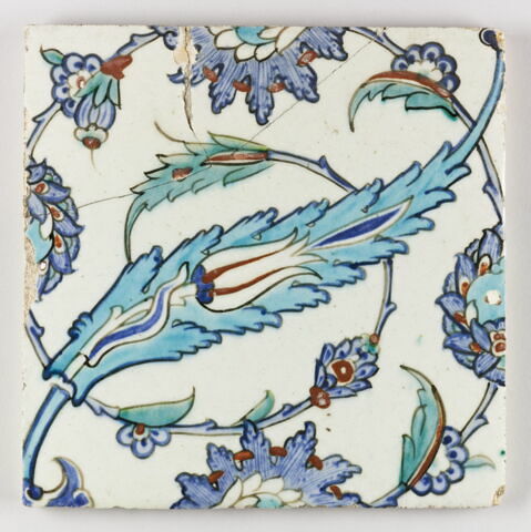 Carreau aux palmettes feuillues, aux feuilles dentelées enfermant une tulipe et aux fleurs épanouies saz