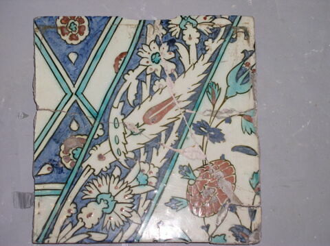 Carreau à la bande diagonale décorée d'un rinceau d'oeillets, de tulipes et de feuilles dentelées