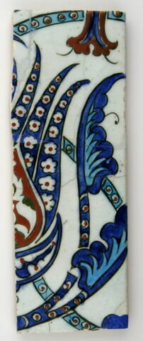 Fragment de carreau à la frise ondulante de tulipes monumentales fleuronnées et fleuries  et de longues feuilles dentelées