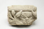 Fragment de tailloir décoré d'un masque barbu et de deux départs de rinceaux constitués de palmettes et de pommes de pin, image 1/4
